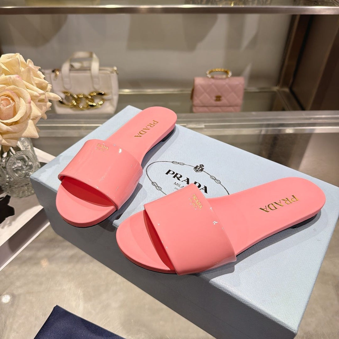 PRADA 26S LOGO EMBOSSED SLIDE SANDALS IN PINK PATENT CALFSKIN