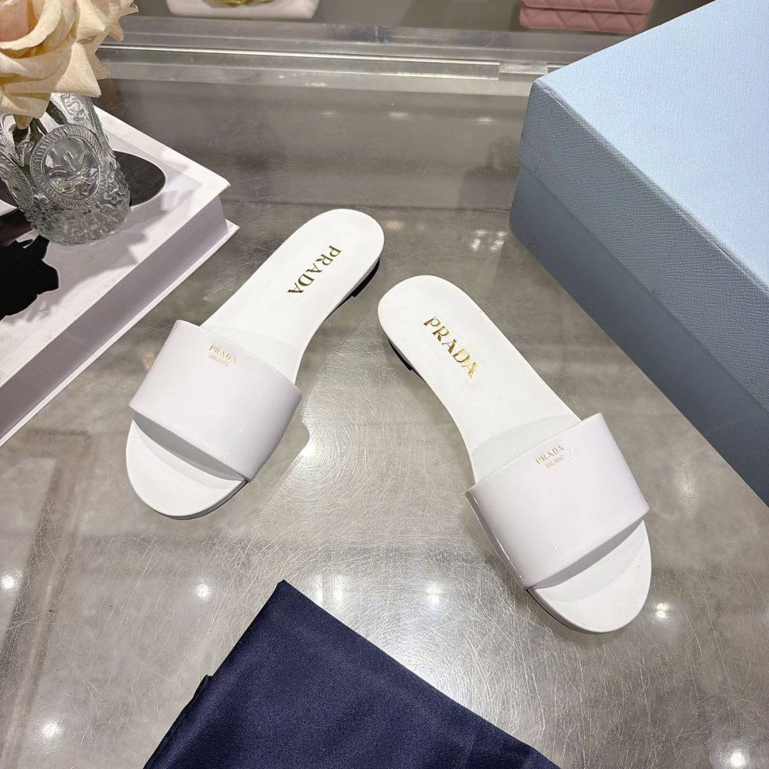 PRADA 26S LOGO EMBOSSED SLIDE SANDALS IN WHITE PATENT CALFSKIN