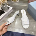 PRADA 26S LOGO EMBOSSED KITTEN HEEL MULES IN WHITE PATENT CALFSKIN