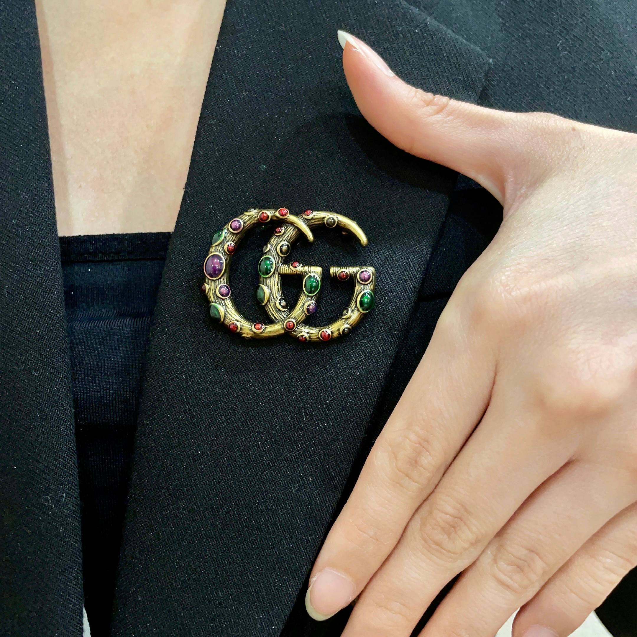 GUCCI 26S INTERLOCKING G MULTICOLOR GEM LOGO BROOCH IN ANTIQUE GOLD TONE METAL 625634