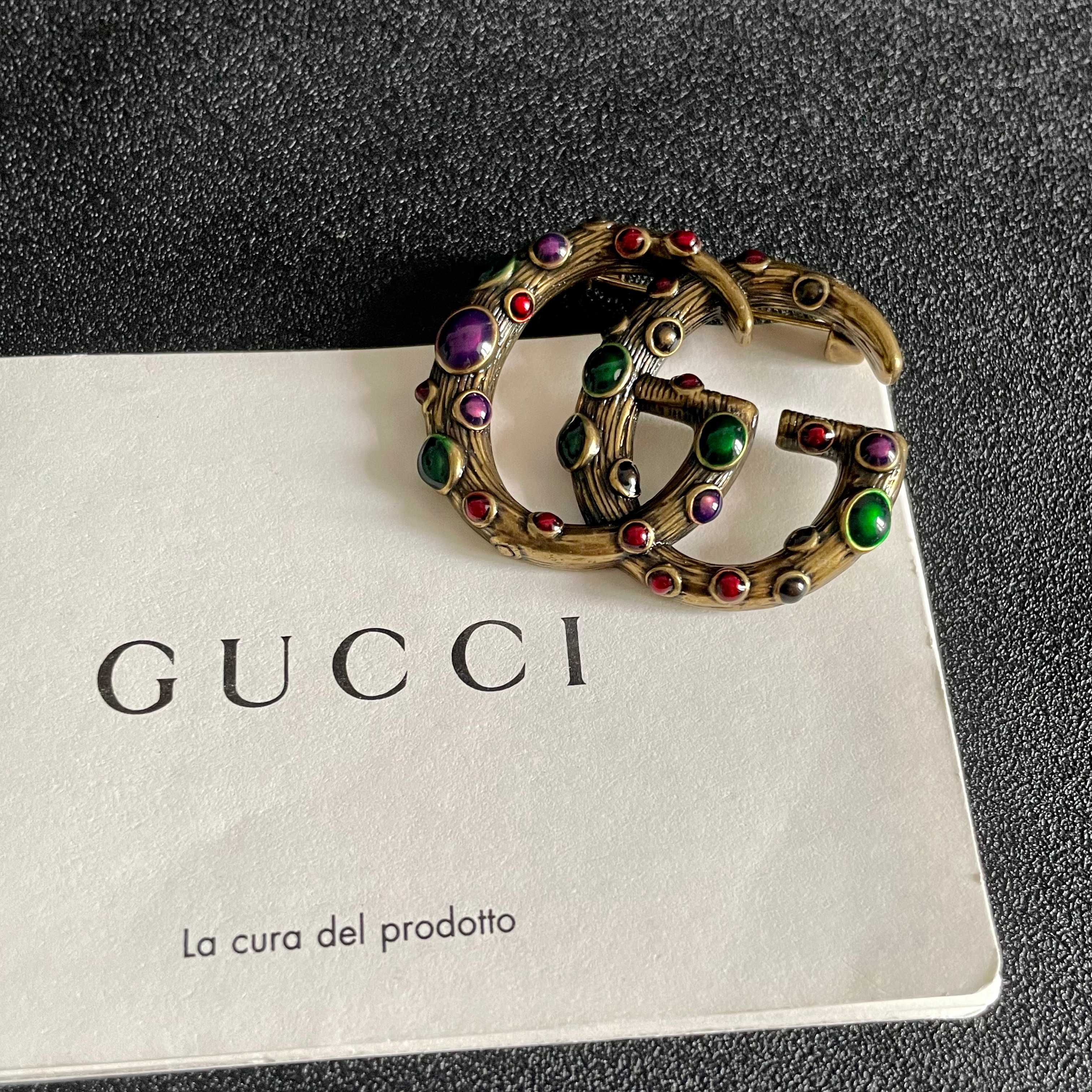 GUCCI 26S INTERLOCKING G MULTICOLOR GEM LOGO BROOCH IN ANTIQUE GOLD TONE METAL 625634