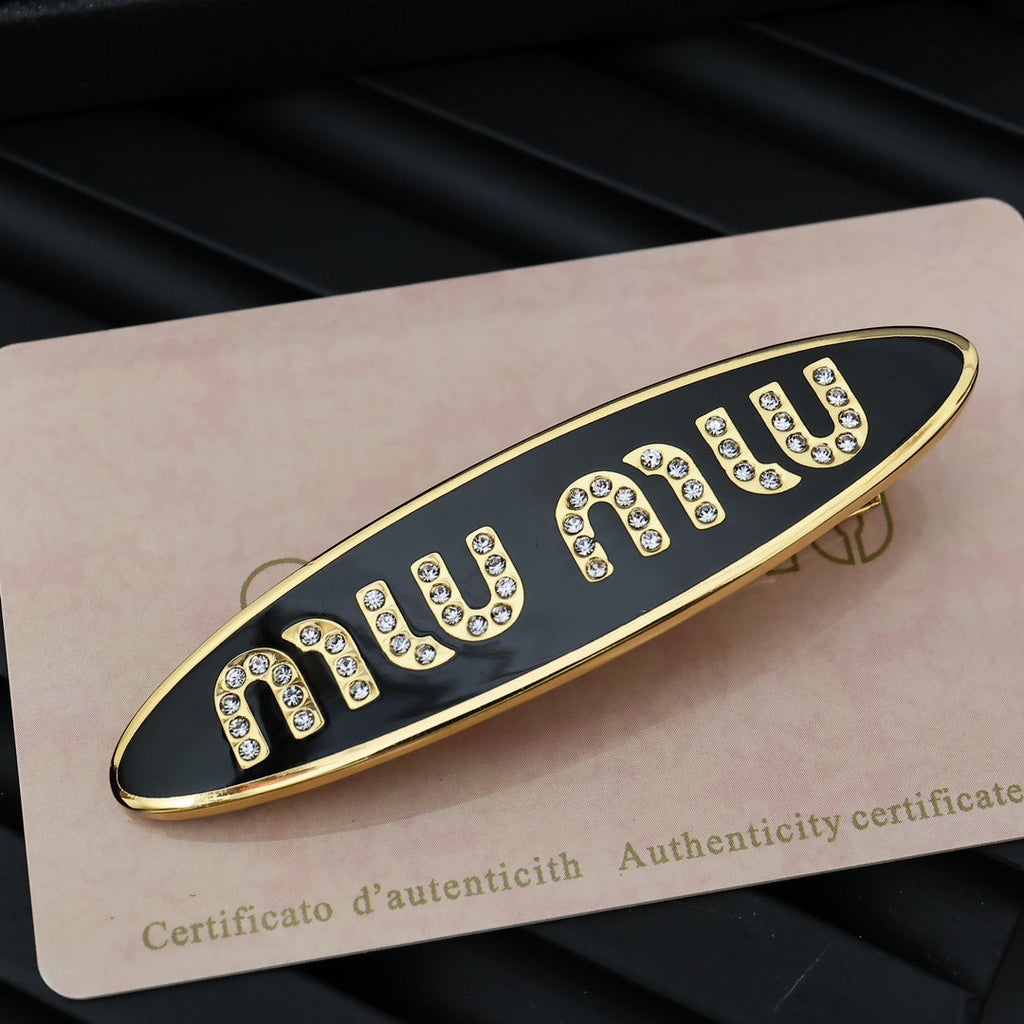 MIUMIU 26S CRYSTAL LOGO HAIR CLIP IN BLACK ENAMEL AND GOLD TONE METAL 626894