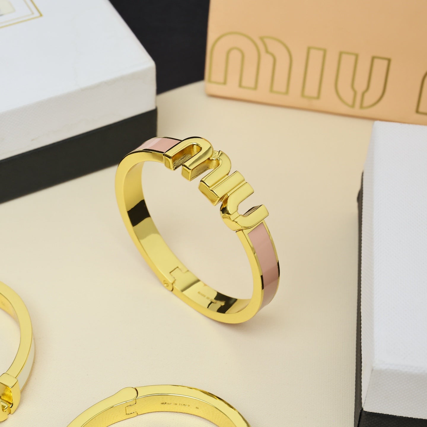 MIUMIU 26S LOGO HINGED BANGLE BRACELET WITH PINK ENAMEL IN GOLD TONE METAL