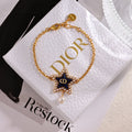 CD 26S PEARL STAR LOGO CHARM BRACELET IN GOLD TONE METAL