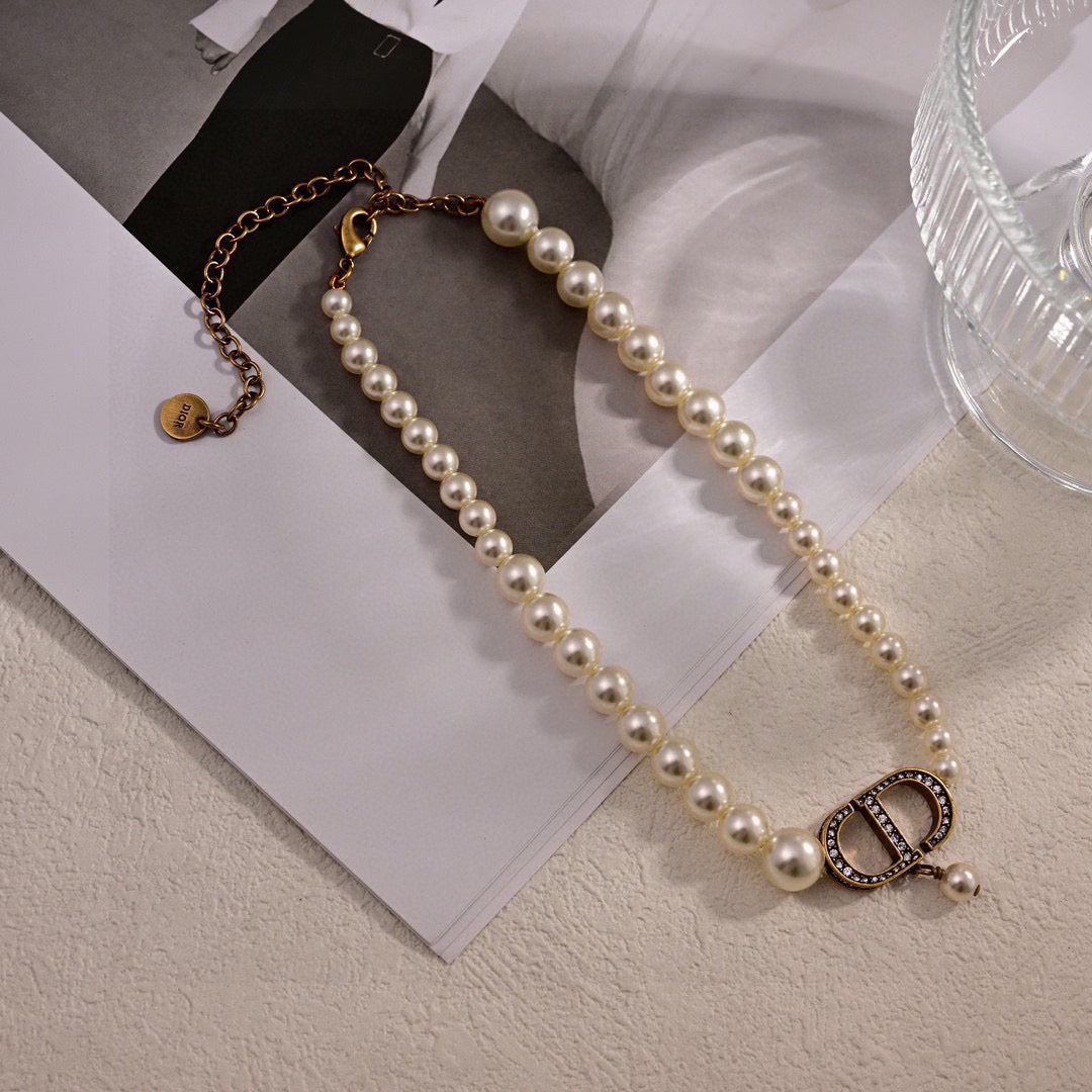 CD 26S PEARL STRAND CD CRYSTAL LOGO DROP NECKLACE IN GOLD TONE METAL 631858
