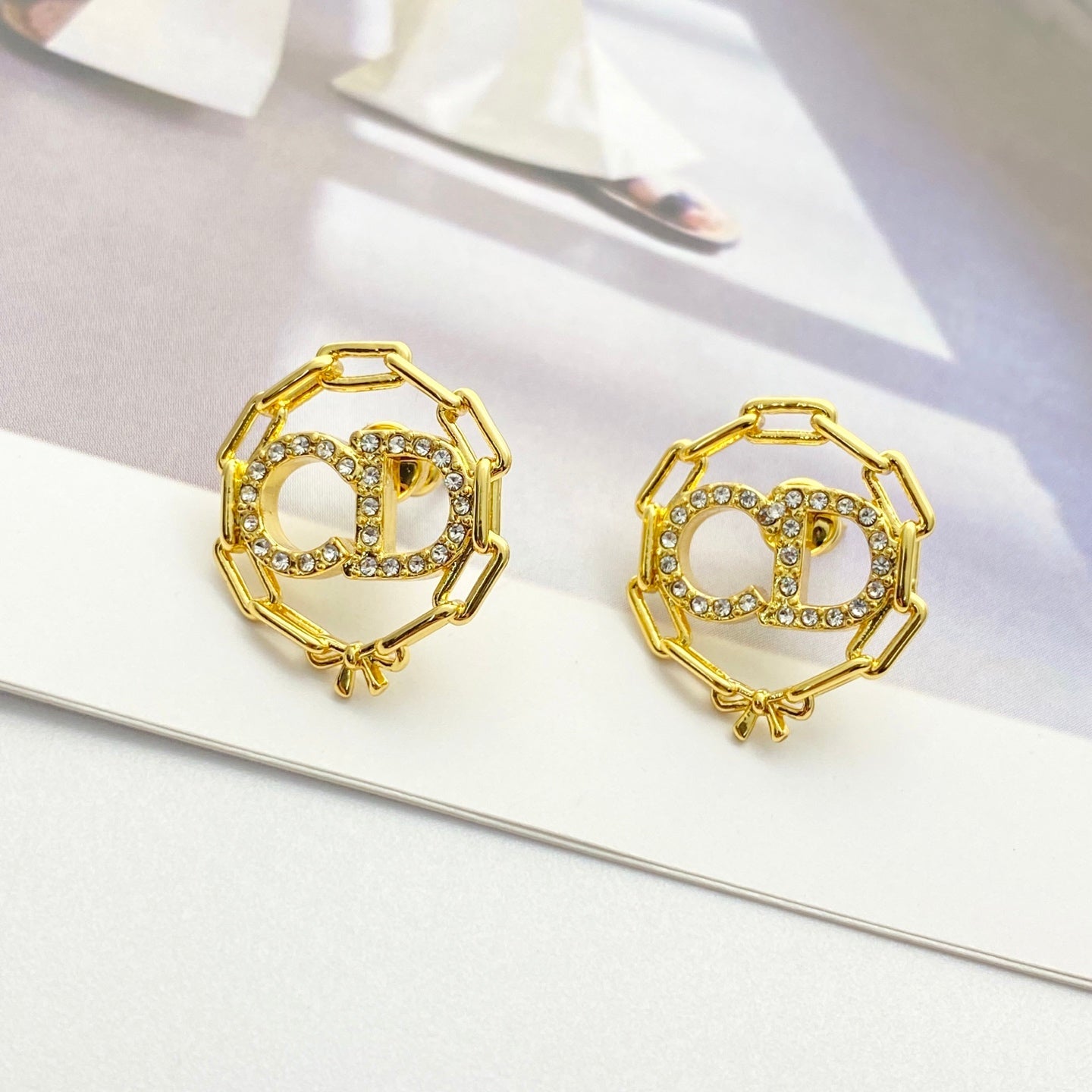 CD 26S CRYSTAL CHAIN LOGO STUD EARRINGS IN GOLD TONE METAL 645655